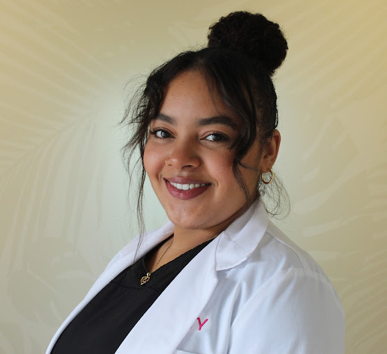 A woman in a lab coat smiling for the camera