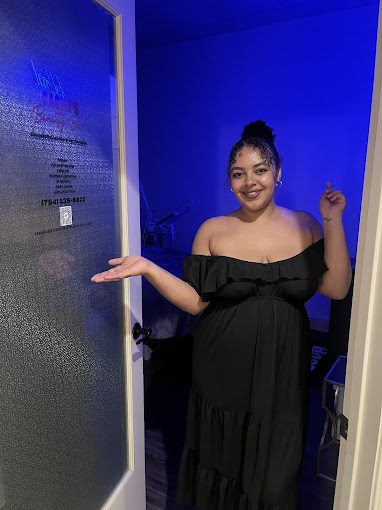 A woman in a black dress standing in a doorway