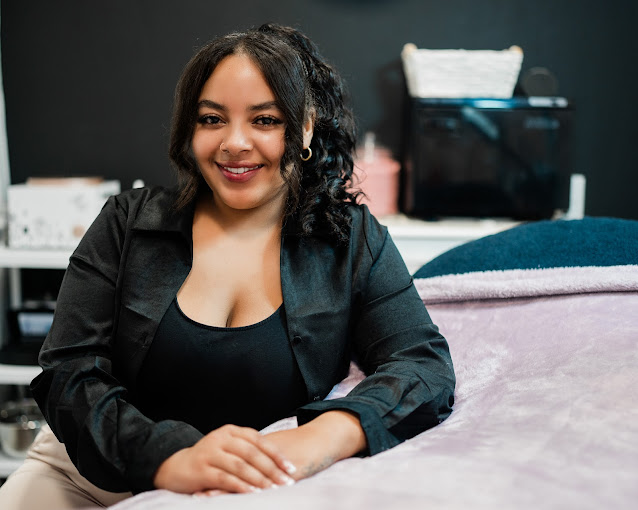 A woman sitting on a bed smiling for the camera