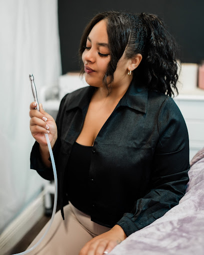 A woman sitting on a bed holding a hair dryer