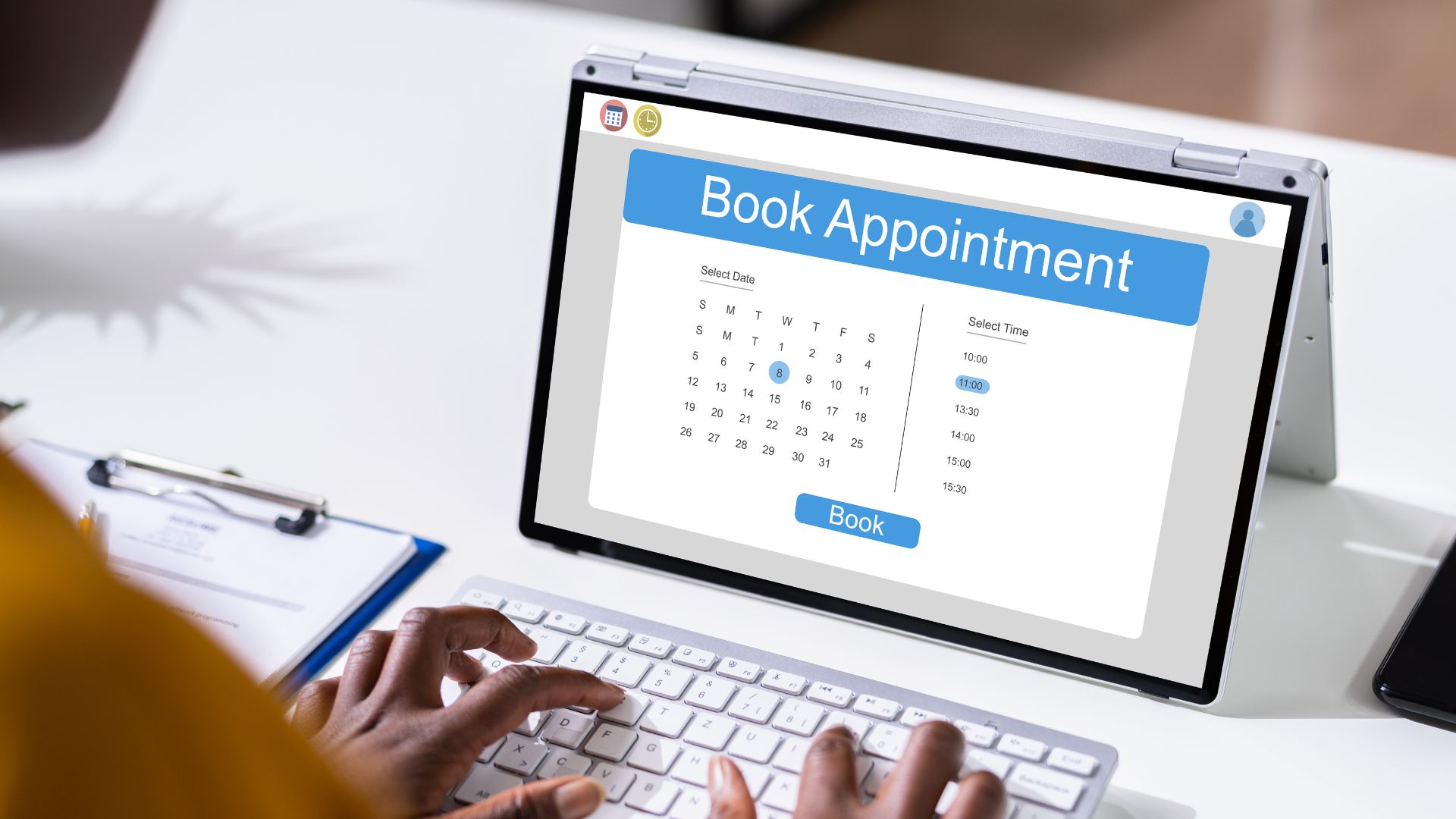 A person typing on a laptop with a book appointment screen